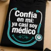 Camiseta médica de humor con el texto Confía en mí: ya casi soy médico y un diseño minimalista de estetoscopio en forma de sonrisa